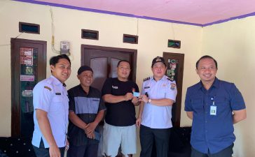 Salah satu warga menerima langsung KTP yang dibagikan Kades kadu, Rabu (16/4/2025). (Istimewa)