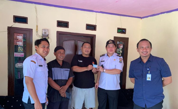 Salah satu warga menerima langsung KTP yang dibagikan Kades kadu, Rabu (16/4/2025). (Istimewa)